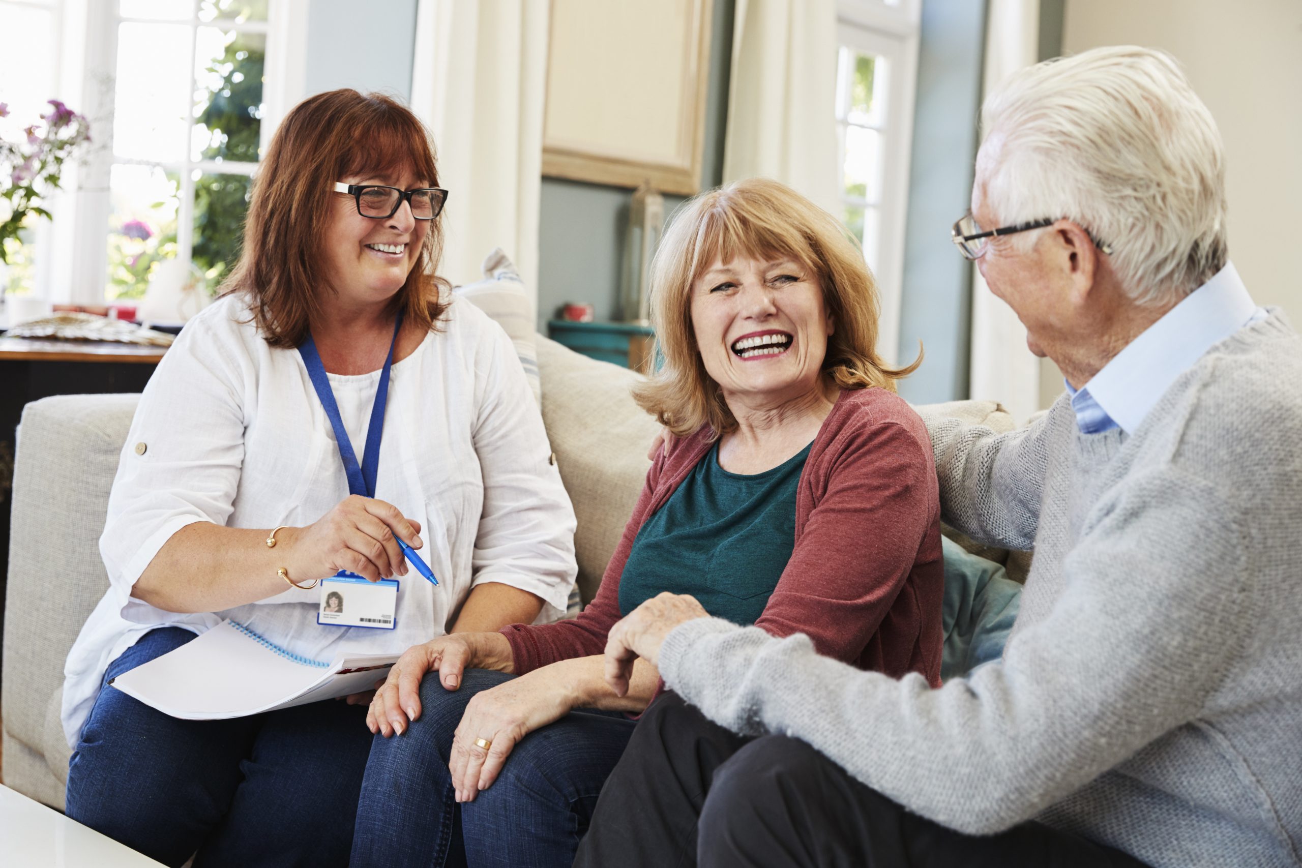 Older couple sitting on couch with clinical staff member