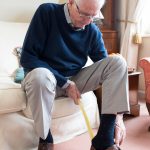 Senior Man Using Long Handled Shoe Horn To Put On Shoes