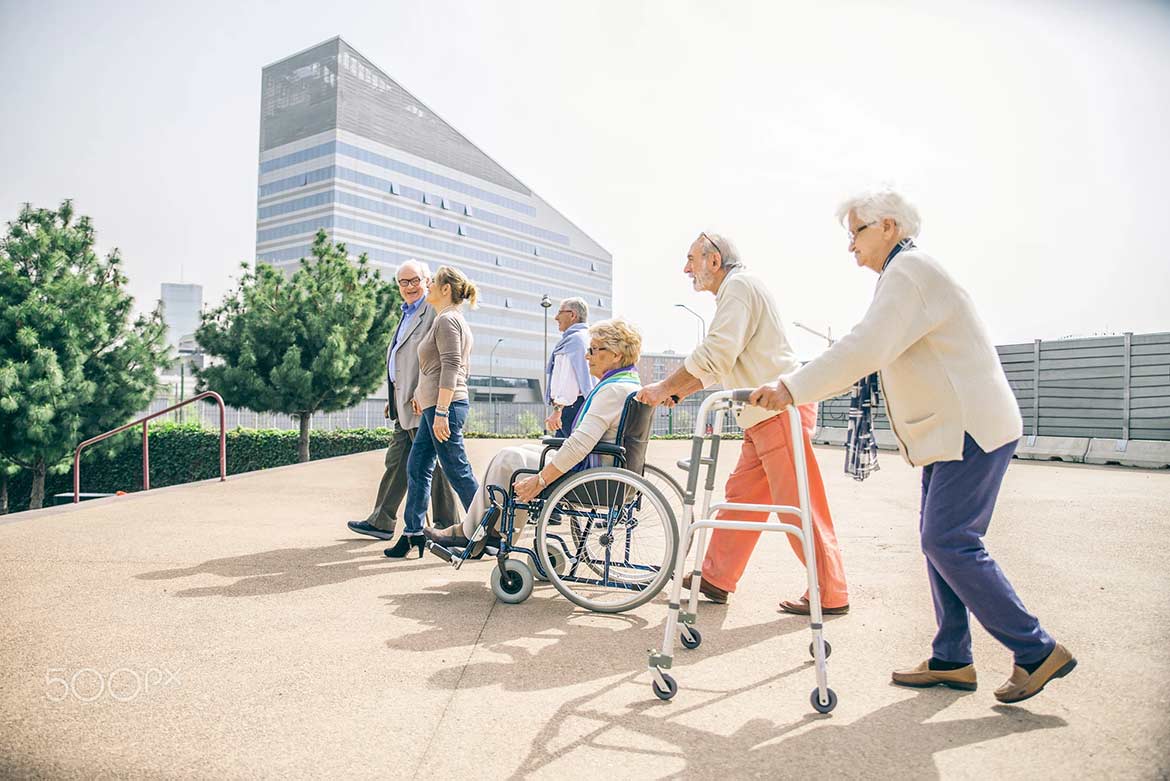 Group of elderly people in wheelchairs and walkers