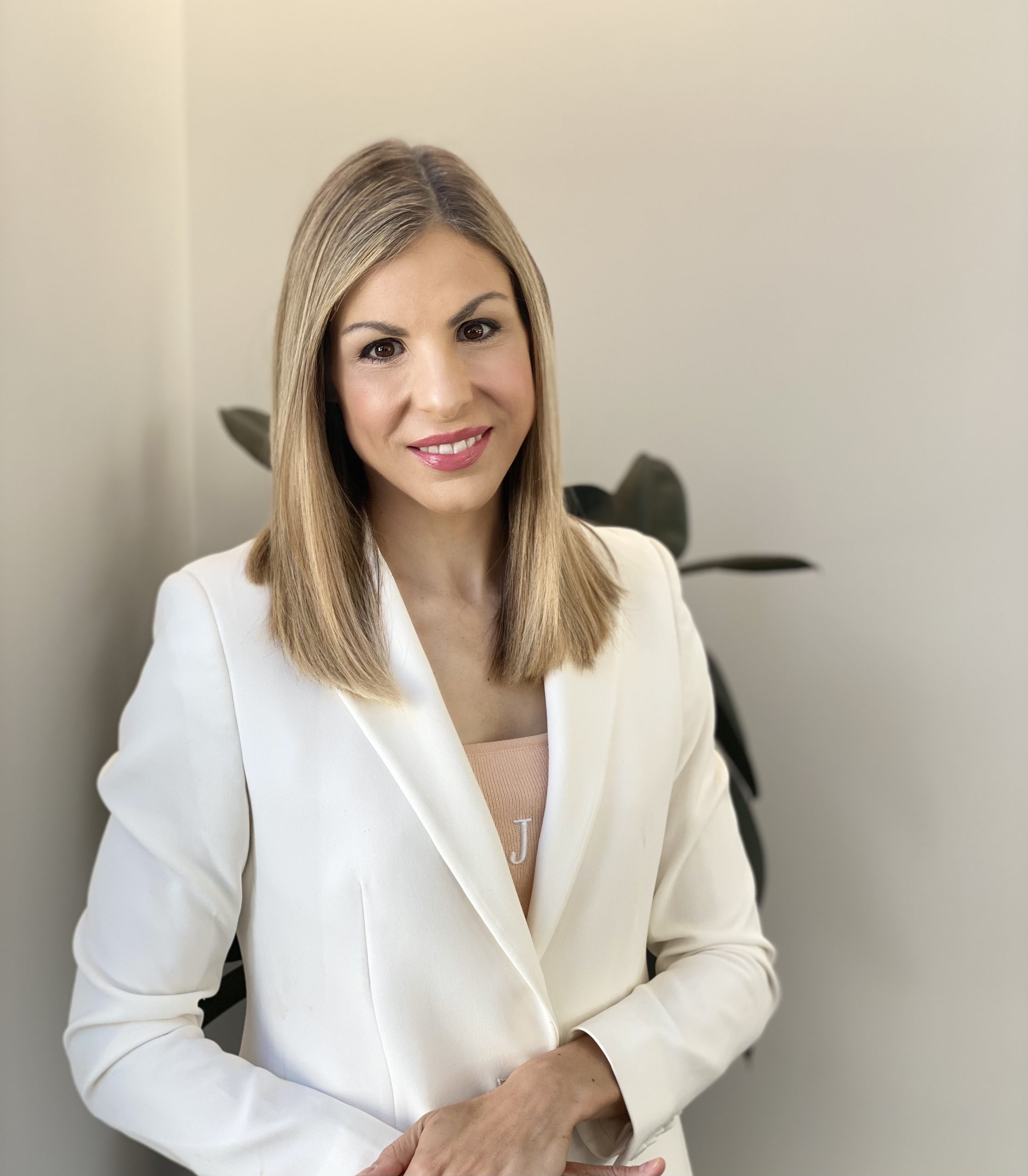 Image of General Manager Marketing, Communications and Projects, Olivia Barnhurst, smiling at the camera with one hand over the other