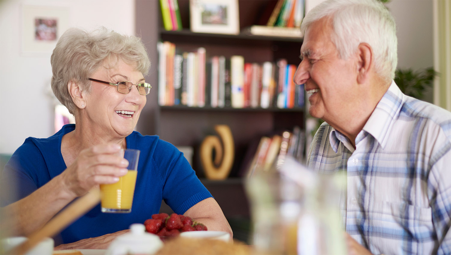 An elderly couple sharing a laugh and looking at each other