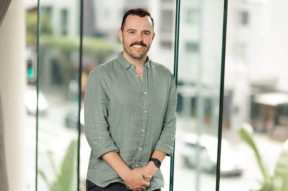 Image of Executive General Manager - Service Delivery for Claro Aged Care and Disability Services, Cameron Hare, smiling at the camera with his hands together