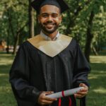 male graduate in graduation gown smiling